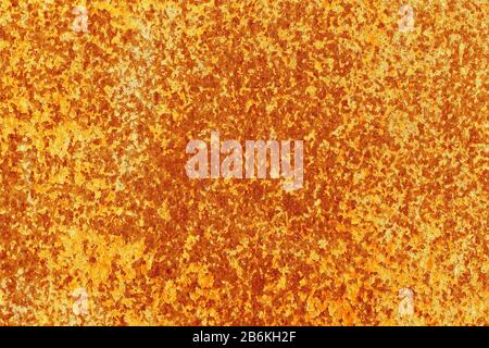 Old peeling cracked paint on an abandoned rusty sheet of metal. Abstract modern trendy red yellow rusty texture background Stock Photo