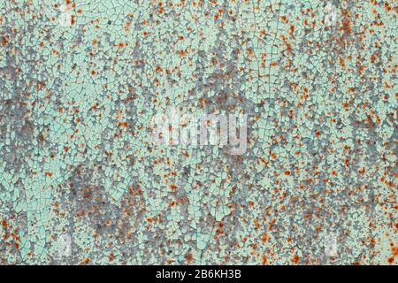 Old peeling turquoise paint with spots of rust on a sheet of metal. Abstract trendy modern texture background Stock Photo
