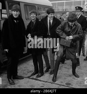 Left to right: John Lennon, Ringo Starr, Paul McCartney and George Harrison at Heathrow Airport before flying out for a series of engagements in Sweden. Stock Photo