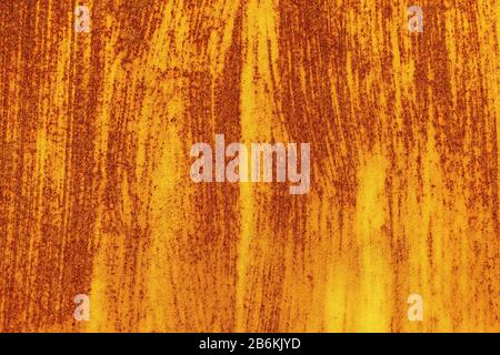 Traces of brush strokes on the surface of an old abandoned rusty sheet of metal. Abstract trendy yellow red rusty texture background Stock Photo