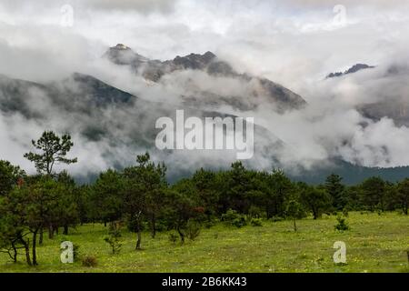 Jade Dragon Snow Mountain, Yulong Xueshan, breaking through clouds and mist at Lijiang, Yunnan Province, China. Glaciers can be seen all year round. Stock Photo