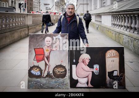 London, UK. 11th March, 2020. Budget 2020: Political artist Kaya Mar poses in Whitehall with his latest budget parody paintings as Chancellor Rishi Sunak prepares to deliver his first budget statement to the House of Commons. Credit: Guy Corbishley/Alamy Live News Stock Photo