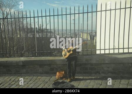 Guitarist performing on a cobbled street in Paris 18e, pasakdek Stock Photo