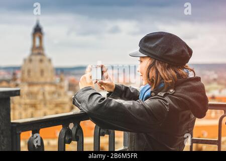 Young woman tourist making photo in the old town of Dresden, Germany, from the observation point Stock Photo