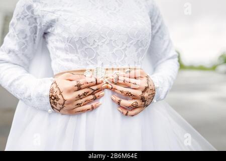 Close-up of hands decorated with a picture of a mehendi of a Muslim bride at a wedding ceremony nikah Stock Photo