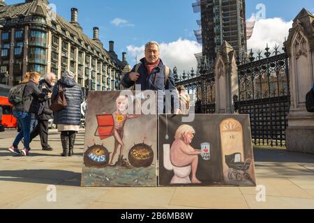 Westminster, London, UK. 11th Mar, 2020. Artist Kaya Mar outside the Houses of parliament with his latest painting depicting Prime Minister Johnson and Dominic Cummings. Penelope Barritt/Alamy Live News Stock Photo