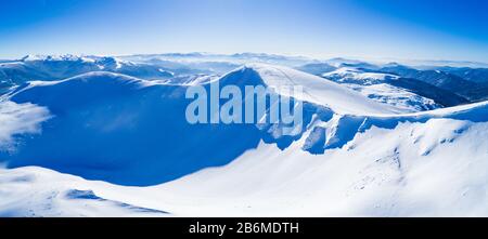 Wonderful giant snowdrifts on the hills in the mountains covered in snow on a sunny frosty winter day. Mountain vacation concept in europe. Copyspace Stock Photo