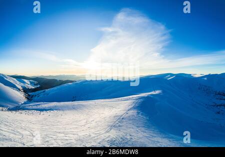 Wonderful day panorama of snowdrifts in the mountains among the forests on a sunny frosty foggy day. The concept of pristine wilderness of the norther Stock Photo