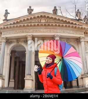 Happy woman drinks water from a hot thermal spring in Karlovy Vary, Czech Republic at winter time Stock Photo