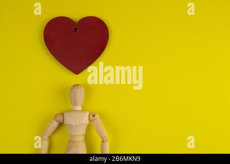 Handcrafted wooden man figure mannequin model dummy doll with with red heart Stock Photo