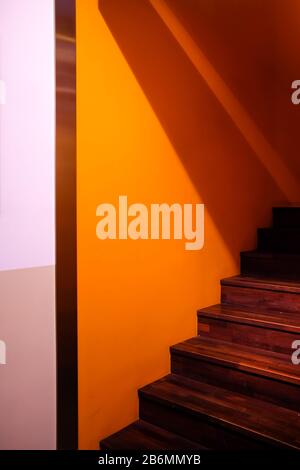 wooden staircase made from laminate wood in yellow wall Stock Photo