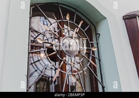 Clock made from vintage cutlery at the entrance to the restaurant Stock Photo