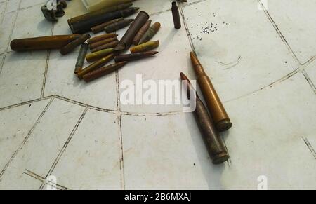 ancient collection of military bullets dating back to the Second World War and gunpowder lying on a white plastic table in italy Stock Photo