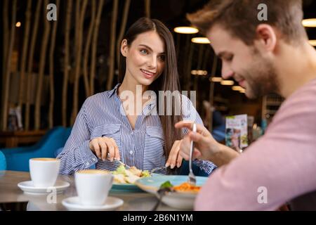 Attractive young couple having lunch at the cafe indoors, having a meal Stock Photo