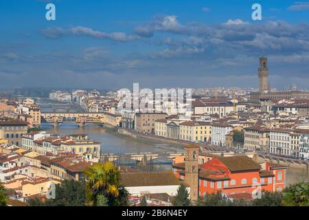 FLORENCE ITALY CITY VIEW WITH  UFFIZI CLOCK TOWER AND PONTE VECCHIO OVER THE RIVER ARNO BLUE SKY AND CLOUDS