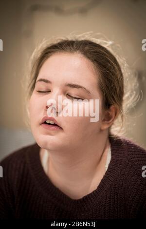 Face only, close up portrait of a tired 14 year old teenage girl with her eyes closed Stock Photo