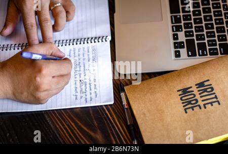 Taking Note Concept. Hand of a young businessman taking notes with a fountain pen on a notecopy. Student learning online. Blogger. Stock Photo