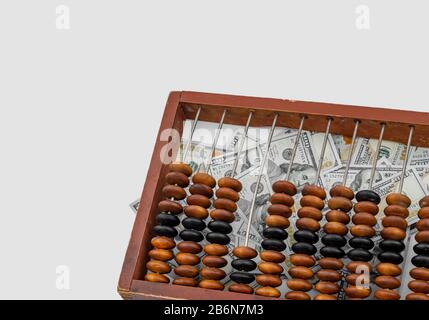 Old wooden abacus on a paper american dollars background. Bookkeeping, profit, business concept Stock Photo