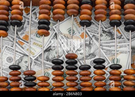 Old wooden abacus on a paper american dollars background. Bookkeeping, profit, business concept Stock Photo