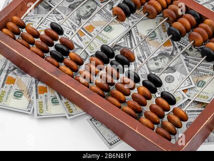 Old wooden abacus on a paper american dollars background. Bookkeeping, profit, business concept Stock Photo