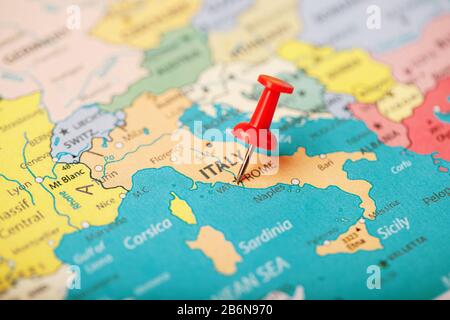 The location of the destination on the map of Italy is indicated by a red pushpin. Italy is marked on the map with a red button Stock Photo