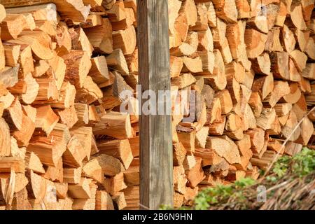 Closeup of a heap of firewood lying piled up in a garden. Seen in Germany in March. Stock Photo