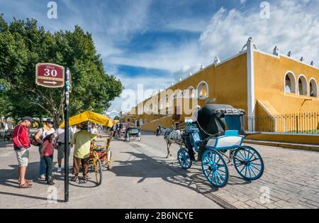 Carriages waiting for tourists at Parque Itzamna, plaza below Convento de San Antonio de Padua, monastery in Izamal, Yucatan state, Mexico Stock Photo