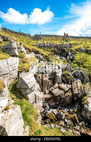 Cyclist (on e-bike) on the Driving Road (Pennine Bridleway) above Dentdale in the Yorkshire Dales Stock Photo