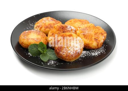 Plate with cheese pancakes and mint isolated on white background Stock Photo