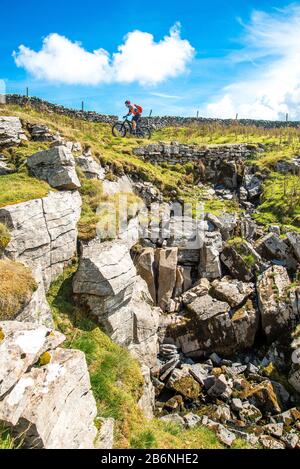 Cyclist (on e-bike) on the Driving Road (Pennine Bridleway) above Dentdale in the Yorkshire Dales Stock Photo