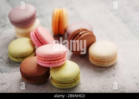 Multicolored macaroni cookies lie on a gray stone slab. Still-life of confectionery products. Stock Photo