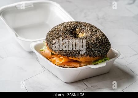 Take Away Salmon Bagel Sandwich with Lox Cream Cheese and Poppy Seeds in Plastic Container Box Package. Organic Healthy Fast Food. Stock Photo