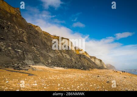 Charmouth, Dorset, UK.  11th March 2020.  UK Weather.  Glorious spring sunshine at Charmouth beach in Dorset looking East towards Golden Cap with the fossil rich cliffs of Stonebarrow showing many landslips from the recent wet stormy weather.  Picture Credit: Graham Hunt/Alamy Live News Stock Photo