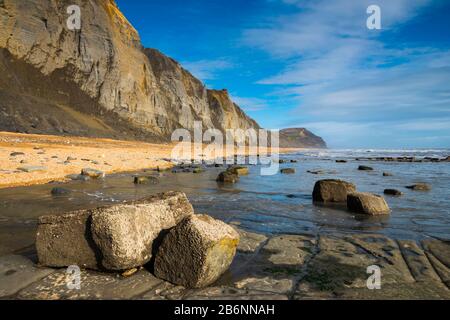 Charmouth, Dorset, UK.  11th March 2020.  UK Weather.  Glorious spring sunshine at Charmouth beach in Dorset looking East towards Golden Cap with the fossil rich cliffs of Stonebarrow showing many landslips from the recent wet stormy weather.  Picture Credit: Graham Hunt/Alamy Live News Stock Photo