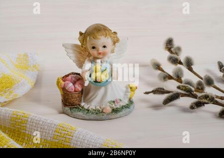 Easter card background. Easter angel with eggs and chickens on a white wooden background. Happy easter. Side view. Stock Photo