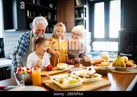 Happy grandchildrens girls having breakfast with her grandparents Stock Photo