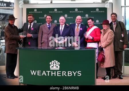 Trainer Willie Mullins (left), Jonny Bairstow, Rory Best, jockey Paul Townend and owners after the Weatherbys Champion Bumper during day two of the Cheltenham Festival at Cheltenham Racecourse. Stock Photo