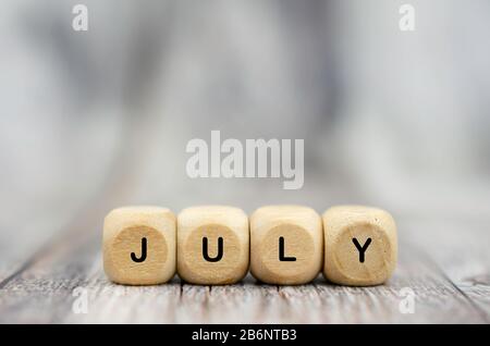 The word July on wooden cubes. Month of year Stock Photo