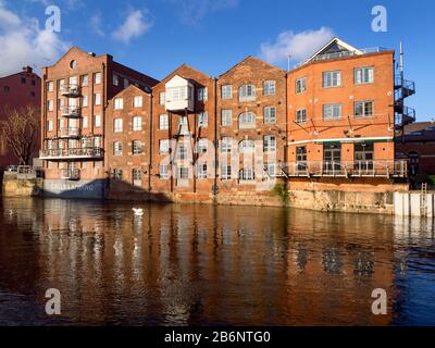 River frontage of former Fletland Mills converted warehouse buildings by the River Aire at Calls Landing in Leeds West Yorkshire England Stock Photo