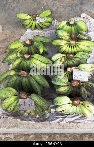 dh PNG Market ALOTAU PAPUA NEW GUINEA Banana fruit markets product display bunches green bananas underripe Stock Photo