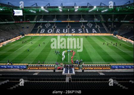 Monchengladach, Germany. 11th Mar, 2020. Bundesliga, Borussia Mönchengladbach - 1 FC Cologne, 21st matchday at Borussia-Park. The players of both teams run into the empty stadium. Due to the corona virus, the game takes place without spectators as a ghost game. Photo: Fabian Strauch/dpa - IMPORTANT NOTE: In accordance with the regulations of the DFL Deutsche Fußball Liga and the DFB Deutscher Fußball-Bund, it is prohibited to exploit or have exploited in the stadium and/or from the game taken photographs in the form of sequence images and/or video-like photo series. Credit: dpa picture allianc Stock Photo