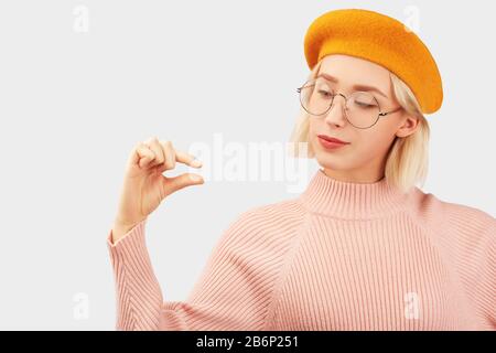 Smiling girl shows little amount of something Stock Photo