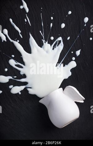 white milk splashes splattered, isolated on black background, nobody Stock Photo