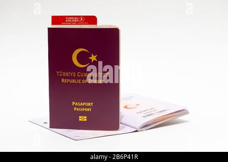 New design Turkish passport with plane travel ticket on white isolated background. Stock Photo