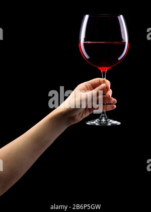 Woman hand holding red wine glass with splashes isolated on black Stock ...