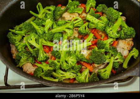 Fried piece of turkey meat with onions and spices. Pieces of turkey carrot onion. The process of cooking vegetable stew with turkey. Steamed vegetable Stock Photo