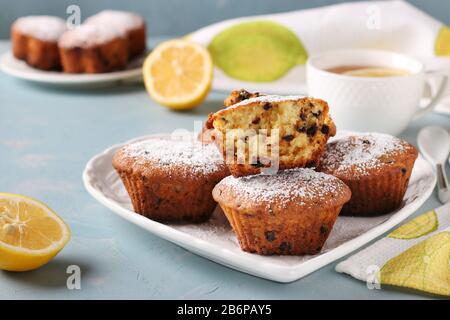 Homemade lemon muffins with chocolate on a white plate on a light blue background Stock Photo