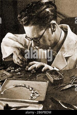 A vintage photograph showing a  jeweller mounting stones in a gem-set necklace Stock Photo