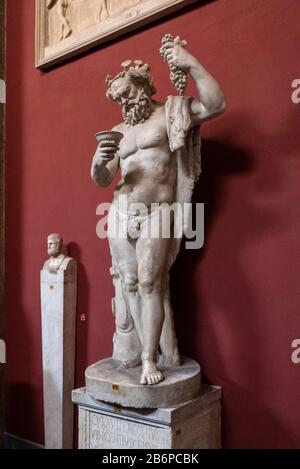 Ancient sculpture of Bacchus, the Roman god of agriculture, wine and fertility. Here with a cluster of grapes in the Vatican Museum, Rome, Italy. Stock Photo