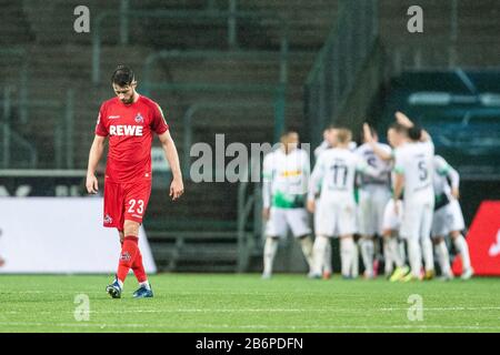 Monchengladach, Germany. 11th Mar, 2020. Mark Uth of Koeln (L) disappointed while team Gladbach celebrate the 2:0 goal during the Bundesliga match Borussia Mönchengladbach vs. 1.FC Köln in the season 2019/2020 (Geisterspiel, ghost game, coronavirus) DFL regulations prohibit any use of photographs as image sequences and/or quasi-video. Credit: Mika Volkmann/Alamy Live News Stock Photo